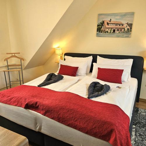 a bedroom with a large bed with red pillows at Haus Scheuten Hotel in Duisburg