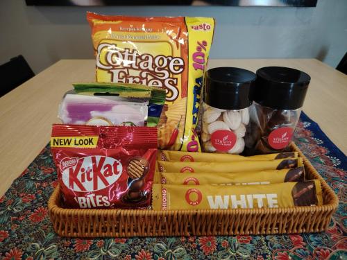 a basket filled with snacks and other items on a table at The Straits Hotel & Suites in Melaka