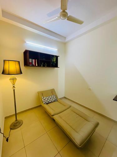 a living room with a couch and a ceiling fan at Sophisticated 2bhk in Bhartiya city near manyata tech park in Yelahanka