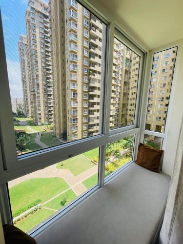 a large window with views of tall buildings at Sophisticated 2bhk in Bhartiya city near manyata tech park in Yelahanka