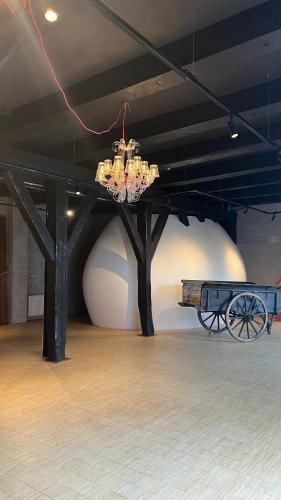 a chandelier is hanging in a room with a bench at Hotel Napoleonschuur in Amerongen