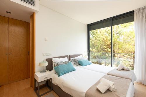 a bedroom with two beds and a large window at VILLA FARHAT in Troia