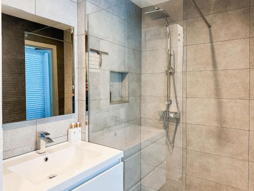 オーステンデにあるModern appartement centrum Oostende met enorm dakterras (parking beschikbaar)の洗面台とガラスのシャワーを備えたバスルーム