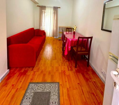 a living room with a red couch and a table at Baligas Apartment in Págoi
