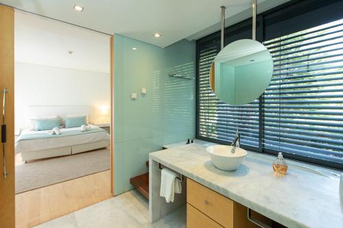 a bathroom with a sink and a bedroom at VILLA FARHAT in Troia