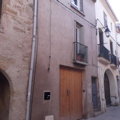 un bâtiment avec une porte en bois sur son côté dans l'établissement Chez René, à Montagnac