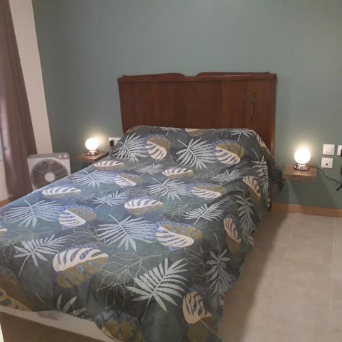 une chambre avec un lit avec une couette bleue et blanche dans l'établissement Chez René, à Montagnac