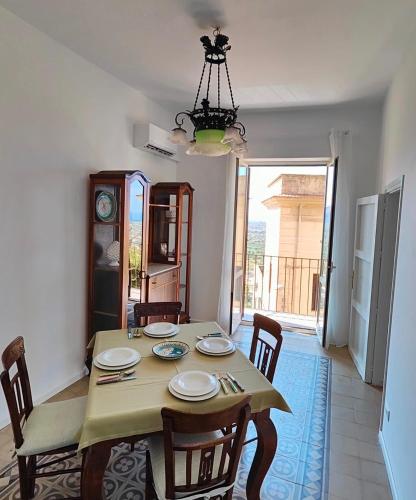 a dining room with a table and chairs and a chandelier at LA CASTELLANA Apartments in Carini