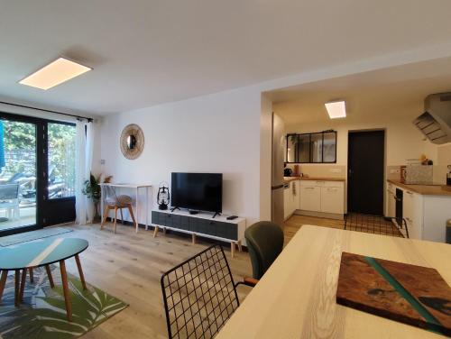 a living room with a dining table and a kitchen at LES "AGATHINES" Maison 4 chambres, de 1 à 9 personnes, deux logements indépendants in Ronce-les-Bains