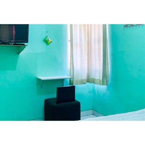 a blue room with a black chair and a table at Surya Inn Syariah Cikarang RedPartner in Bekasi