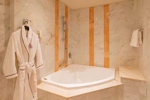 a bathroom with a bath tub and a robe at Hotel Internazionale in Bologna