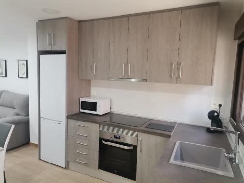 a kitchen with a stove and a microwave at Casa Dolores in Villahermosa del Río