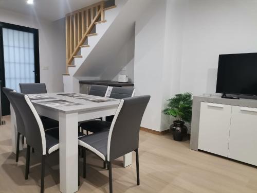 a dining room with a table with chairs and a television at Casa Dolores in Villahermosa del Río