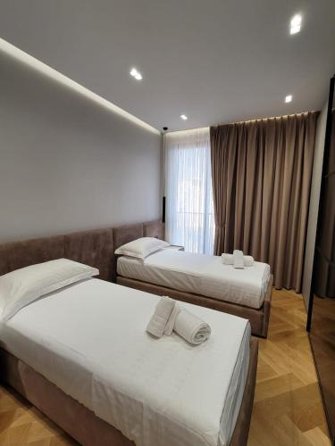 a hotel room with two beds and a window at DAED Luxury Residence in Sarandë