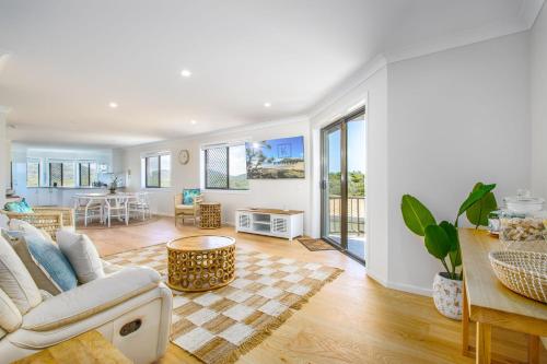 a living room with a couch and a table at Shoreline Holiday Apartment in Hastings Point