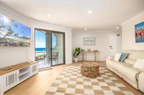a living room with a couch and a table at Shoreline Holiday Apartment in Hastings Point