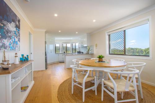 a kitchen and dining room with a table and chairs at Shoreline Holiday Apartment in Hastings Point
