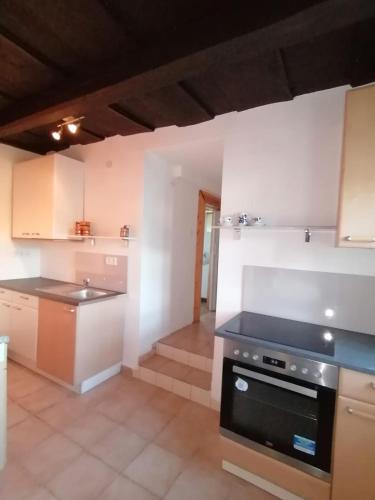a kitchen with white walls and a stove top oven at Das kleine Weinberghäuschen in Garabonc - Jägerpince in Garabonc