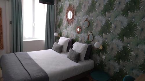 ピエルフ・デュ・バールにあるLogis Hôtel La Clé Des Songesの花柄の壁のベッドのある寝室