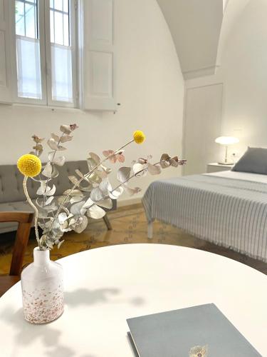a vase with flowers on a table in a bedroom at Tenuta Villa Vittoria in Copertino