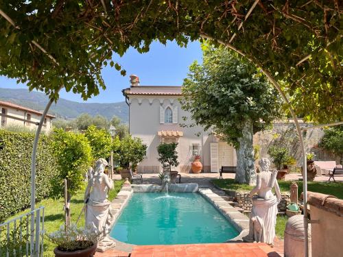 a pool with statues in front of a house at B&B Ninfeo dell' Arancera in Calci