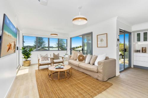 a living room with a couch and a table at Dreamtime Villa in Kingscliff
