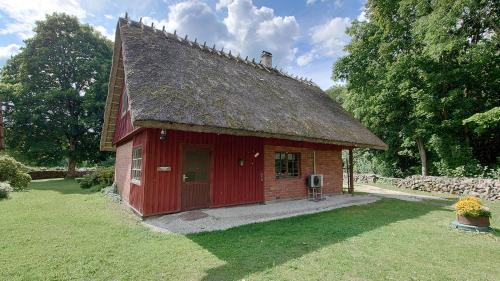 a small red building with a roof at Vahtra-Reinu puhkemaja in Siiksare