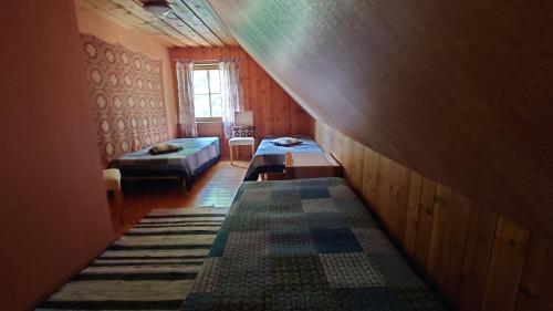 a attic room with a bed and a table in it at Vahtra-Reinu puhkemaja in Siiksare