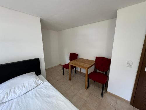a bedroom with a bed and a table and two chairs at HIDO Landhaus am See in Xanten