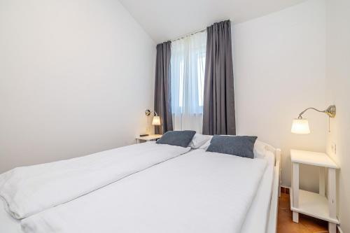 a bedroom with a white bed and a window at Villa Haya with heated pool in Linardići
