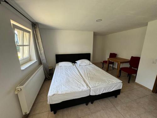 a bedroom with a bed and a table and chairs at HIDO Landhaus am See in Xanten