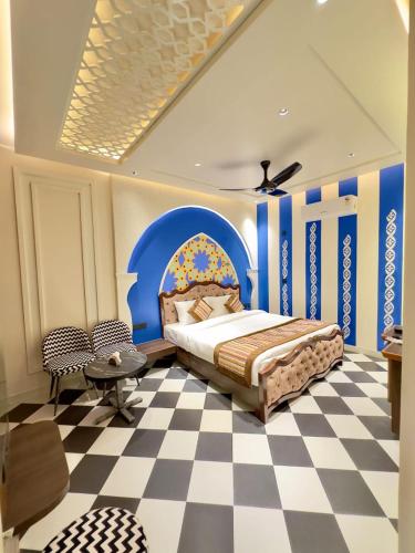 a bedroom with a bed and a checkered floor at Hotel Grand Kailash Haveli in Kotdwāra