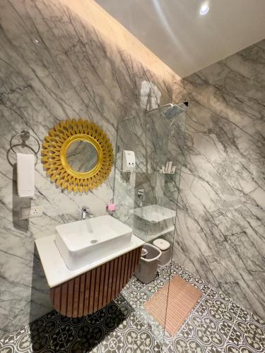 a bathroom with a sink and a mirror at Hotel Grand Kailash Haveli in Kotdwāra
