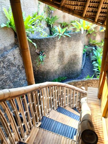 an overhead view of a wooden staircase with plants at Danaswari Bali Bamboo House in Selat