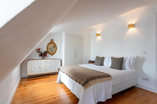 a white bedroom with a bed and a dresser at 54 São Paulo - Exclusive Apartment Hotel in Lisbon