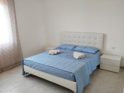 a bedroom with a bed with two towels on it at Appartamento Sankt Johann in San Giovanni Suèrgiu