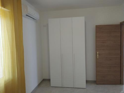 a room with a white closet and a door at Appartamento Sankt Johann in San Giovanni Suèrgiu