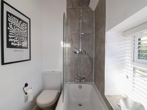 une salle de bain avec toilettes et baignoire dans l'établissement Lavender Cottage, à Bourne