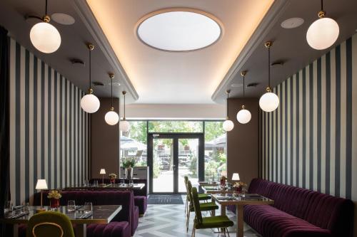 a restaurant with purple chairs and tables and windows at Amsterdam Plaza Hotel & SPA in Palanga