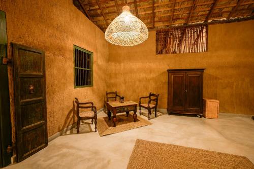 a room with chairs and a table and a chandelier at Yakaduru - Yala in Yala