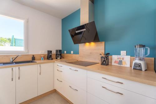 une cuisine avec des armoires blanches et un comptoir dans l'établissement Bienvenue à la Maison 