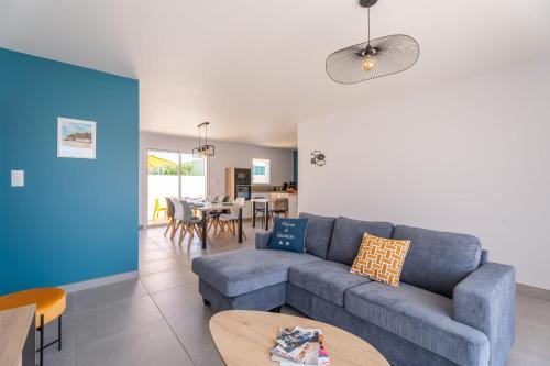 un salon avec un canapé bleu et une table dans l'établissement Bienvenue à la Maison 