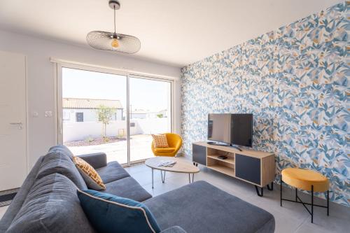 un salon avec un canapé et une télévision dans l'établissement Bienvenue à la Maison 