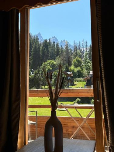 a vase sitting on a table in front of a window at Hôtel Le Jeu de Paume in Chamonix-Mont-Blanc