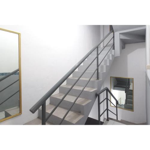 a staircase in a building with a mirror at RedDoorz at Deluxe Hotel near Terminal Purabaya Bungurasih in Sidoarjo