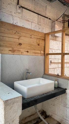 a bathroom with a white sink on a stone wall at pra tiksha farm in Karjat