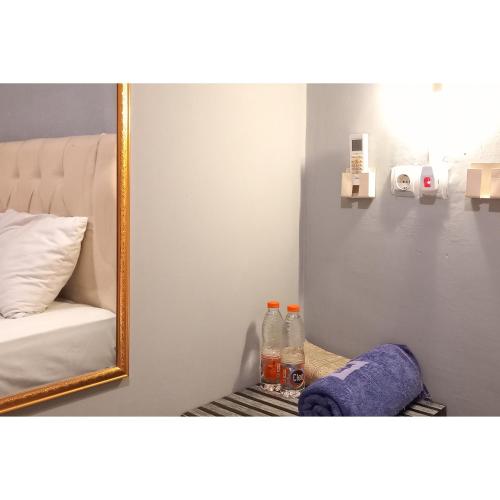 a mirror sitting on a shelf next to a bed at RedDoorz at Deluxe Hotel near Terminal Purabaya Bungurasih in Sidoarjo