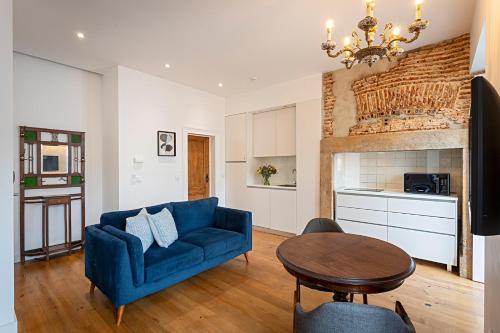 a living room with a blue couch and a table at 54 São Paulo - Exclusive Apartment Hotel in Lisbon
