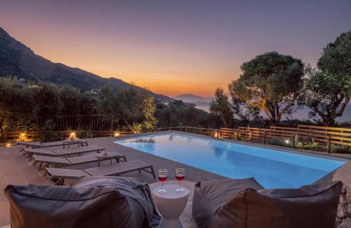 a pool with lounge chairs and a view of the mountains at Villa Cossoro Ena in Zakynthos in Xirokástellon