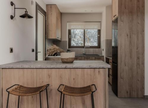 a kitchen with a large island with two bar stools at Villa Cossoro Ena in Zakynthos in Xirokástellon